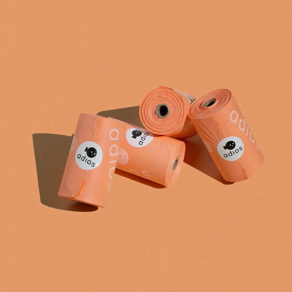 Image of four Coral pink coloured Adios poo bags, biodegradable poop bags for dogs 