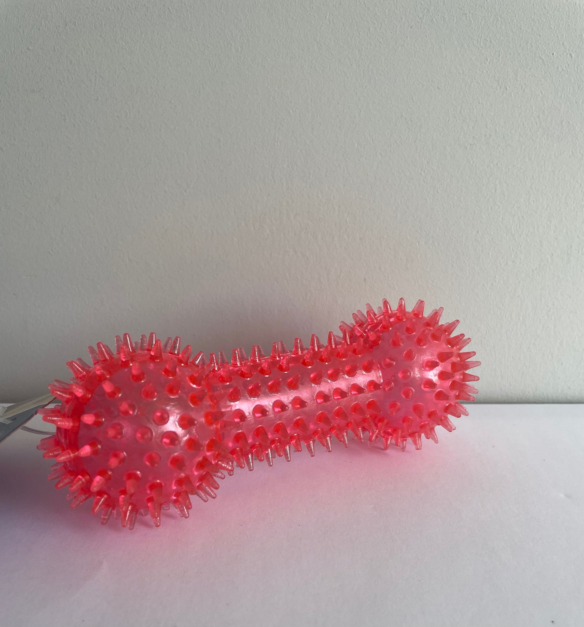 Image of a red spiky textured boned shaped dog toy