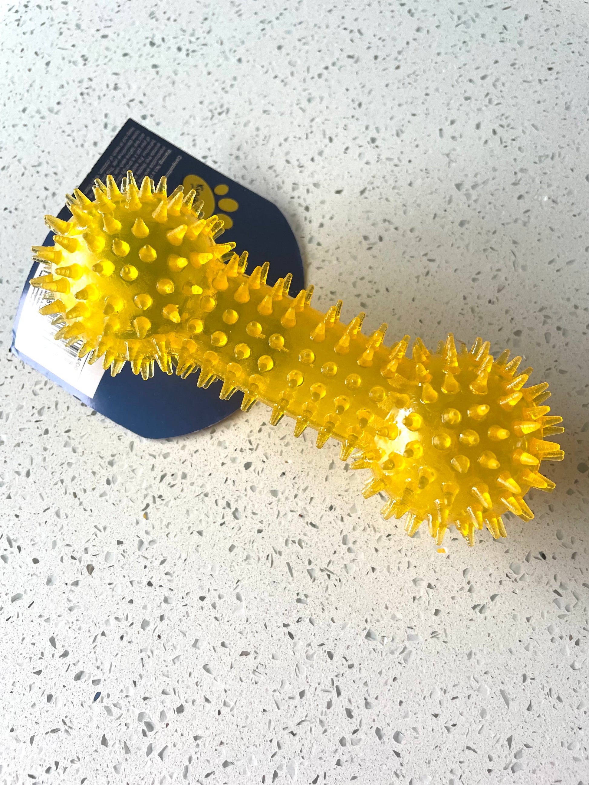 Image of a yellow spiky textured boned shaped dog toy